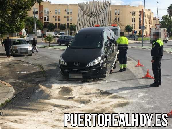 El coche accidentado es remolcado por la grúa.