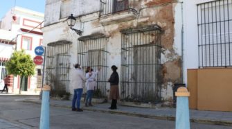 Miembros del PSOE de Puerto Real frente a las viviendas que rehabilitará el Ayuntamiento.