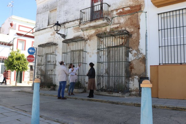 Miembros del PSOE de Puerto Real frente a las viviendas que rehabilitará el Ayuntamiento.