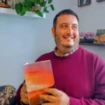 Marcos Ballester sosteniendo su poemario «Verano».
